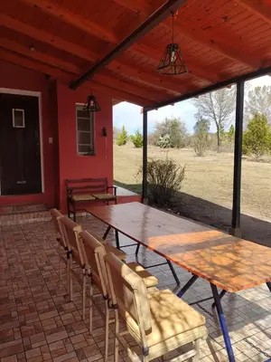 a patio with a table and chairs on a brick patio at La Pasionaria, casa de campo con pileta in Villa García