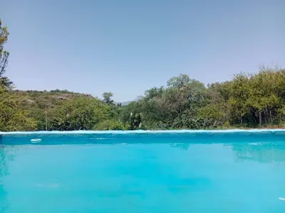 a large body of blue water with trees in the background at La Pasionaria, casa de campo con pileta in Villa García