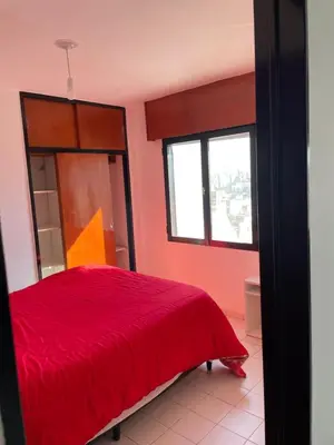a bedroom with a red bed and two windows at DEPARTAMENTO 1 dormitorio plaza Colón en la mejor zona del centro de Córdoba in Cordoba