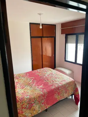 a bedroom with a bed with a red blanket at DEPARTAMENTO 1 dormitorio plaza Colón en la mejor zona del centro de Córdoba in Cordoba