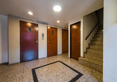 a hallway with doors and stairs with a rug on the floor at DEPARTAMENTO 1 dormitorio plaza Colón en la mejor zona del centro de Córdoba in Cordoba