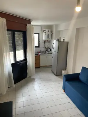 a kitchen with a blue couch and a refrigerator at DEPARTAMENTO 1 dormitorio plaza Colón en la mejor zona del centro de Córdoba in Cordoba