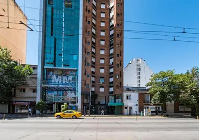 a yellow car parked in front of a tall building at DEPARTAMENTO 1 dormitorio plaza Colón en la mejor zona del centro de Córdoba in Cordoba