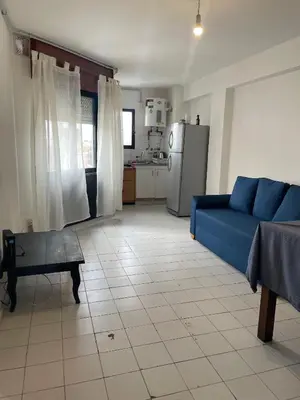 a living room with a blue couch and a kitchen at DEPARTAMENTO 1 dormitorio plaza Colón en la mejor zona del centro de Córdoba in Cordoba