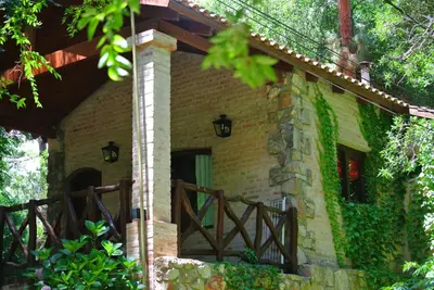 a stone house with a wooden fence in front of it at Las Nubes Cabañas & Loft in San Javier