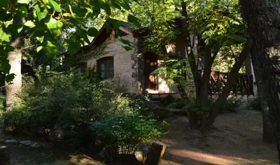 an old stone house in the middle of trees at Las Nubes Cabañas & Loft in San Javier