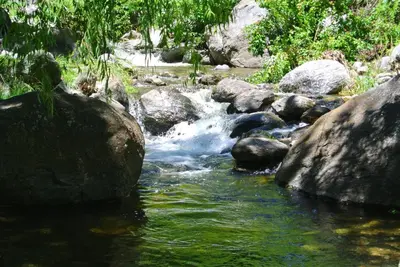 a stream of water with rocks in a river at Las Nubes Cabañas & Loft in San Javier