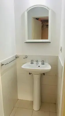 a white bathroom with a sink and a mirror at Carlos Paz Tupungato in Villa Carlos Paz