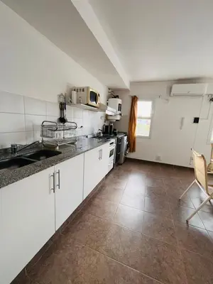 a kitchen with white cabinets and a tile floor at Carlos Paz Tupungato in Villa Carlos Paz