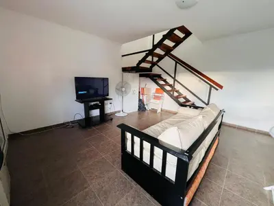 a living room with a bed and a staircase at Carlos Paz Tupungato in Villa Carlos Paz