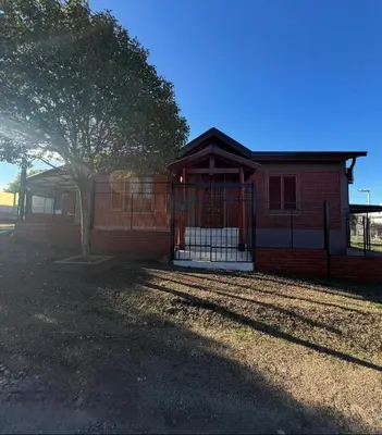 a red brick house with a tree in front of it at Casita serrana in Villa Santa Cruz del Lago