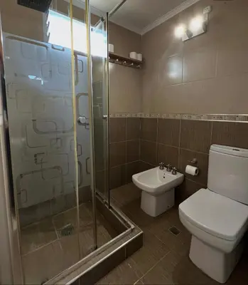 a bathroom with a toilet and a glass shower at Casita serrana in Villa Santa Cruz del Lago