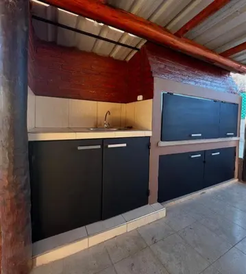 a kitchen with a sink and a tv in a room at Casita serrana in Villa Santa Cruz del Lago