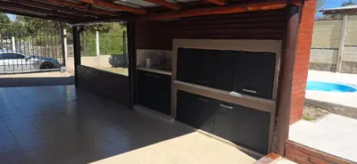 an outdoor kitchen with a large tv on the side of a building at Casita serrana in Villa Santa Cruz del Lago