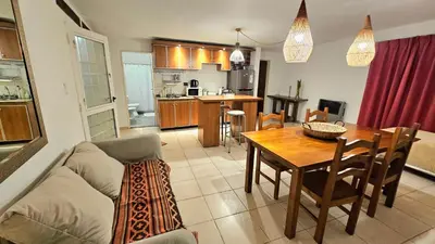 a living room and kitchen with a table and a couch at Temporario Sanatorio Allende Cerro M Suites in Cordoba