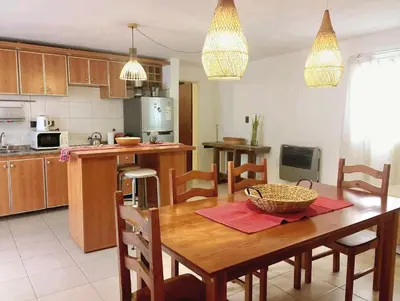 a kitchen with a wooden table and a dining room at Temporario Sanatorio Allende Cerro M Suites in Cordoba
