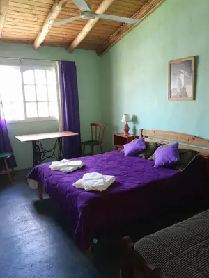 a bedroom with a purple bed with towels on it at Rafael Arcangel in Nono