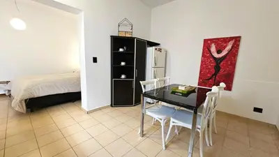 a dining room with a table and chairs and a bed at Mujer Urbana Suite in Cordoba