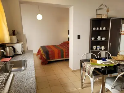 a living room with a bed and a table and a bedroom at Mujer Urbana Suite in Cordoba