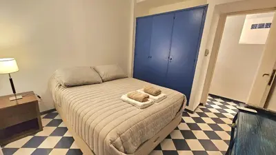 a small bed in a room with a blue door at Mujer Urbana Suite in Cordoba