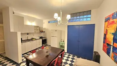a kitchen with a table and a blue door at Mujer Urbana Suite in Cordoba