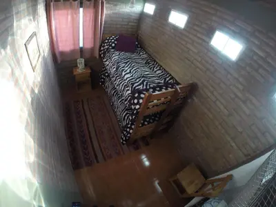 a small bedroom with a bed in a brick wall at Cabañas Y Departamentos Bettylu in Villa Cura Brochero
