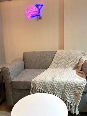 a living room with a couch and a neon sign at Departamento 