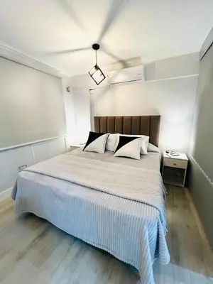 a bedroom with a large white bed in a room at Departamento 