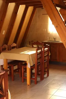a kitchen with a table and chairs in a room at ALPINAS DeL MONTE in Cortaderas