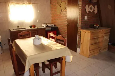 a kitchen with a table with chairs and a sink at ALPINAS DeL MONTE in Cortaderas