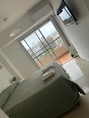 a large bed in a room with a large window at Departamento tres dormitorios excelente ubicación Nueva Córdoba in Cordoba