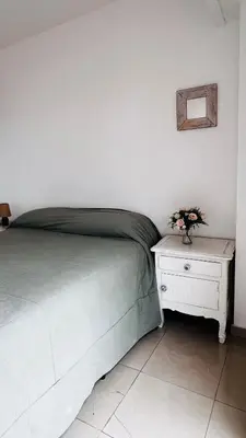 a bedroom with a bed and a nightstand with flowers on it at Departamento tres dormitorios excelente ubicación Nueva Córdoba in Cordoba