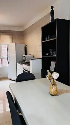 a kitchen with a table with chairs and a refrigerator at Departamento tres dormitorios excelente ubicación Nueva Córdoba in Cordoba