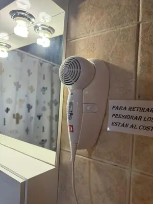 a hair dryer in a bathroom next to a mirror at Cabañas Pindahue - Alojamineto Epehuen in Villa Carlos Paz