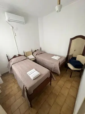 a room with two beds and a mirror at Centro Cordoba in Cordoba