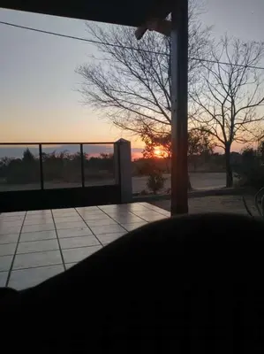 a view of the sunset from a porch with a pole at Alojamiento Mabel in Merlo