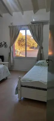 a bedroom with a bed and a large window at Alojamiento Mabel in Merlo