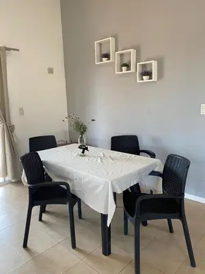 a dining room table with a white tablecloth and chairs at Alojamiento Mabel in Merlo