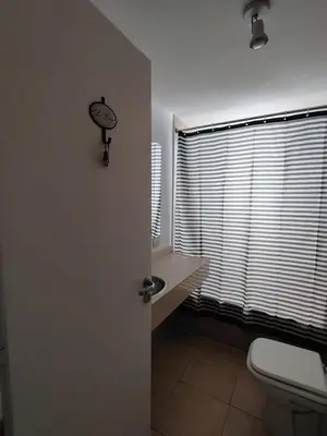 a bathroom with a toilet and a clock on the wall at Güemes Premium, 1 dorm Ubicación Estratégica ALOHA #5 in Cordoba