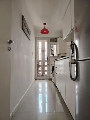 a kitchen with white appliances and a red light at Güemes Premium, 1 dorm Ubicación Estratégica ALOHA #5 in Cordoba