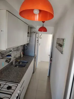 a kitchen with white cabinets and an orange light at Güemes Premium, 1 dorm Ubicación Estratégica ALOHA #5 in Cordoba
