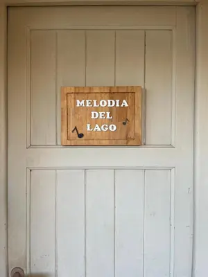 a sign on a door that says meloda del lagapo at Melodía del lago in Villa Carlos Paz