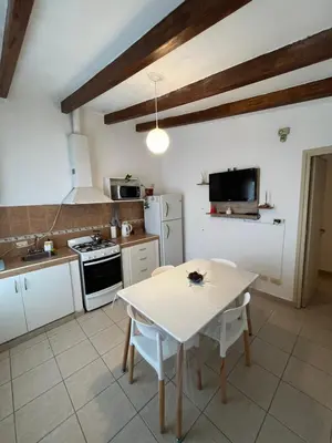 a kitchen with a white table and a white stove at Melodía del lago in Villa Carlos Paz