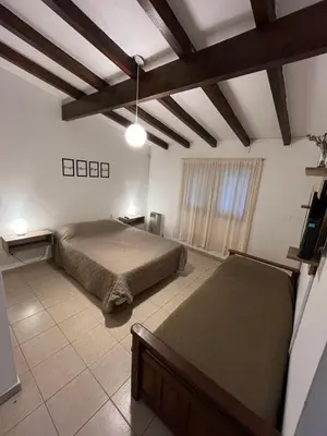 a bedroom with a bed in a room with wooden ceilings at Melodía del lago in Villa Carlos Paz