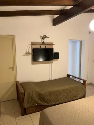 a bedroom with a bed and a flat screen tv at Melodía del lago in Villa Carlos Paz