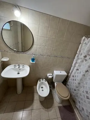a bathroom with a sink and a toilet and a mirror at Melodía del lago in Villa Carlos Paz
