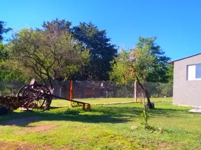 an old tractor sitting in the grass in a yard at Punilla- Don Americo in Villa Carlos Paz