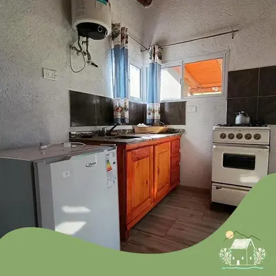 a kitchen with a white refrigerator and a stove at Punilla- Don Americo in Villa Carlos Paz