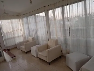 a waiting room with white chairs and windows at Hotel inti huasi in Villa Carlos Paz