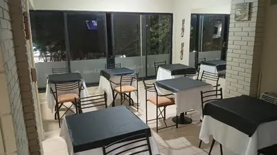 a row of tables and chairs in a room with windows at Hotel inti huasi in Villa Carlos Paz